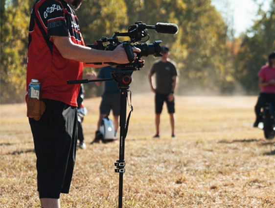 Camera operator filming riders at a circuit event